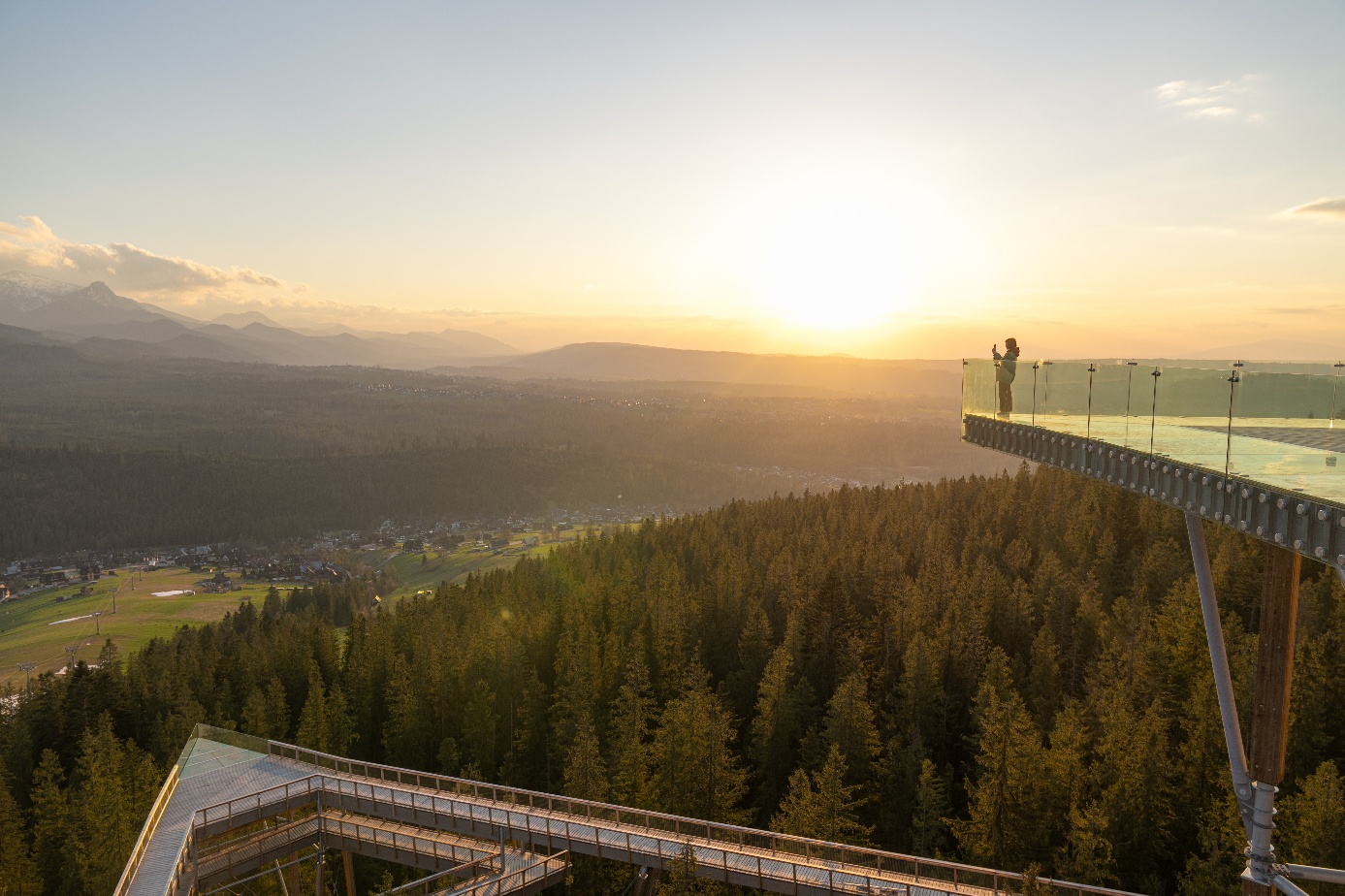 Szklany taras Sky Walk Poronin z widokiem na okolicę w świetle zachodzącego słońca